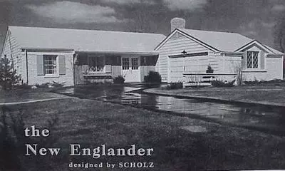 A black and white photograph of a ranch style Scholz-designed home with a manicured lawn and long driveway